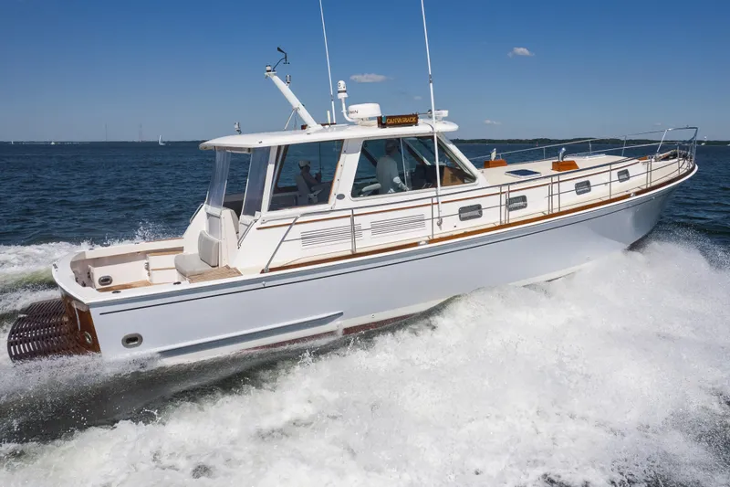 Slide: The Image of 1999 Grand Banks 49 Eastbay HX cruising on open water under clear blue skies. - 64