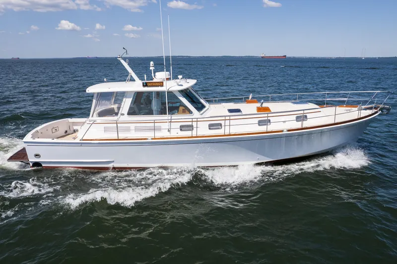 Slide: The Image of 1999 Grand Banks 49 Eastbay HX cruising on open water under a clear sky. - 7