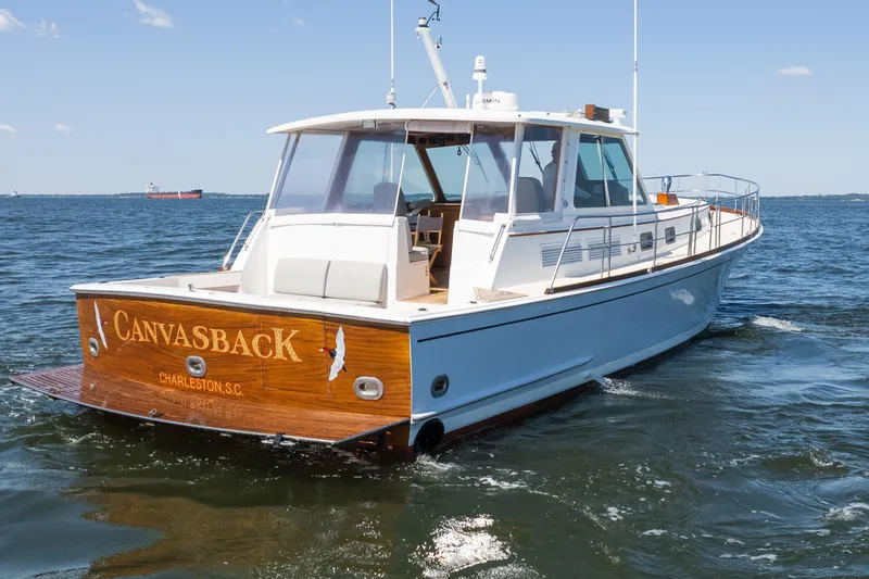 Slide: The Image of 1999 Grand Banks 49 Eastbay HX yacht on open water, rear view with "Canvasback" name. - 8
