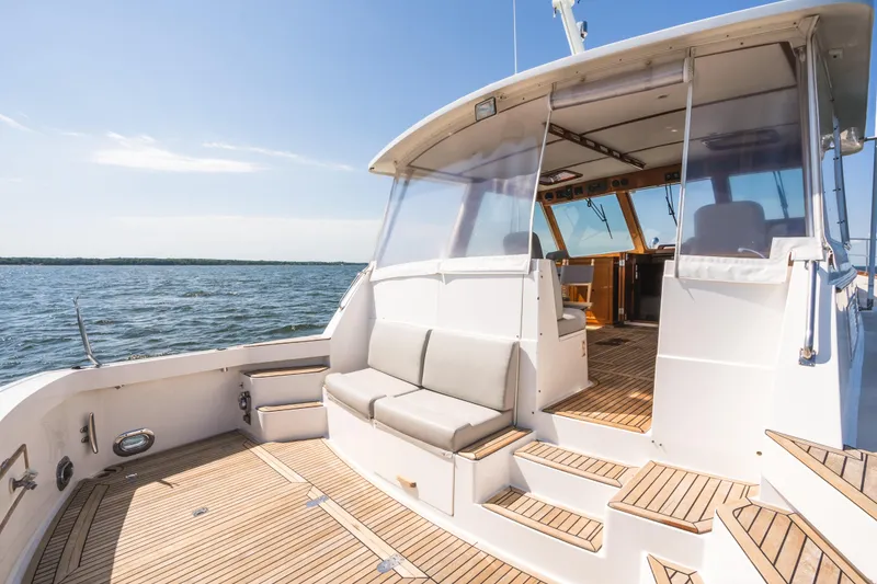 Slide: The Image of 1999 Grand Banks 49 Eastbay HX yacht with teak deck and seating, cruising on open water. - 9