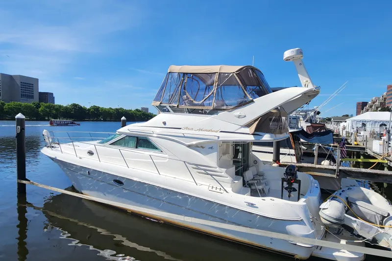 The Image of 2001 Sea Ray 400 Sedan Bridge yacht docked at a marina under clear blue skies. - 0