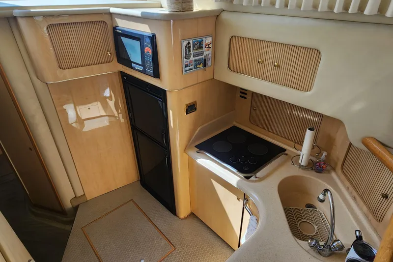 Slide: The Image of 2001 Sea Ray 400 Sedan Bridge yacht kitchen with stove, sink, and microwave. - 14