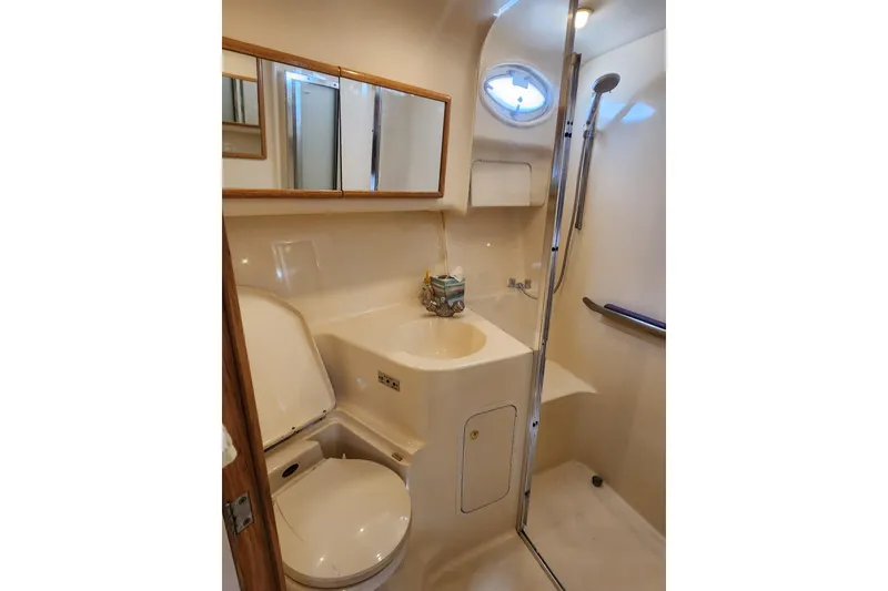 Slide: The Image of Bathroom interior of 2001 Sea Ray 400 Sedan Bridge yacht, featuring sink, toilet, and shower. - 27