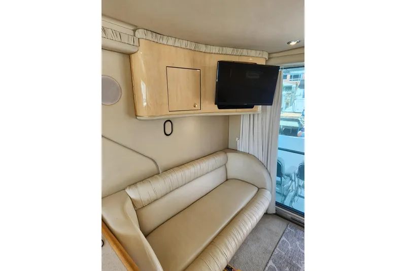 Slide: The Image of Interior of 2001 Sea Ray 400 Sedan Bridge with beige seating and mounted TV. - 29