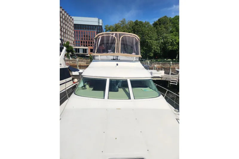 Slide: The Image of 2001 Sea Ray 400 Sedan Bridge yacht docked, featuring a spacious flybridge and sleek design. - 3