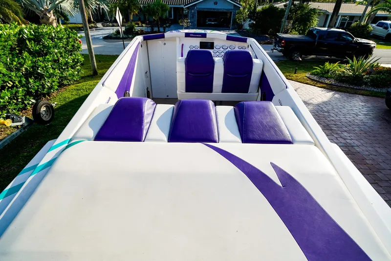 Slide: The Image of 2000 Active Thunder 32 boat with purple and white interior, parked in a residential driveway. - 3