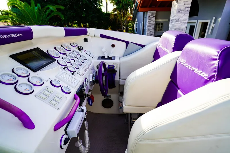 Slide: The Image of Interior of a 2000 Active Thunder 32 boat with purple and white seating and control panel. - 9