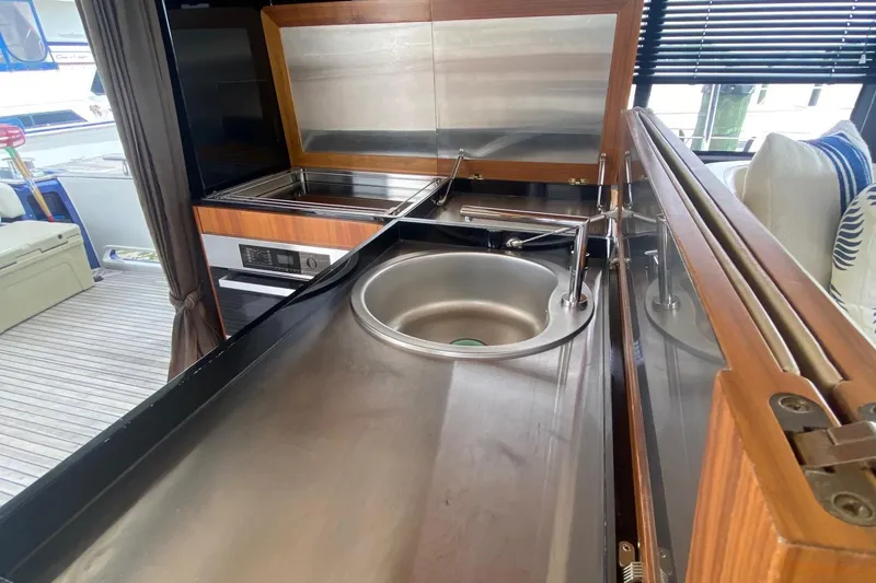 Slide: The Image of Modern kitchen area on a 2014 Azimut Magellano 50 yacht, featuring sleek stainless steel surfaces. - 20