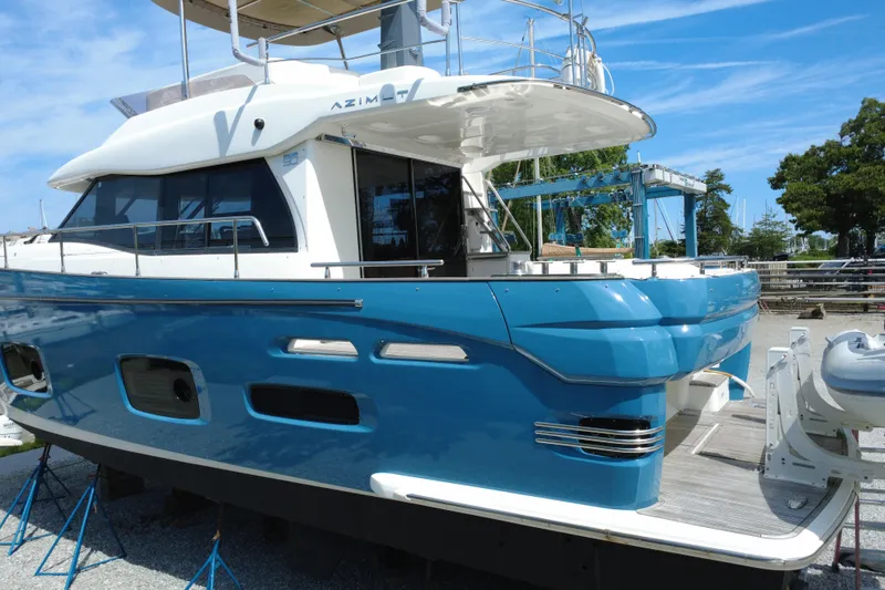 Slide: The Image of 2014 Azimut Magellano 50 yacht with blue hull, docked outdoors. - 43