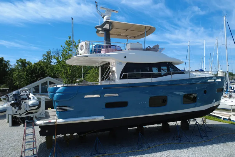 Slide: The Image of Azimut Magellano 50 yacht, 2014 model, displayed on stands in a marina setting. - 8
