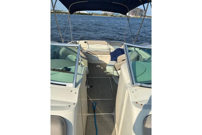 Slide: The Image of 2004 Sea Ray 240 Sundeck boat interior with seating, canopy, and water view. - 9