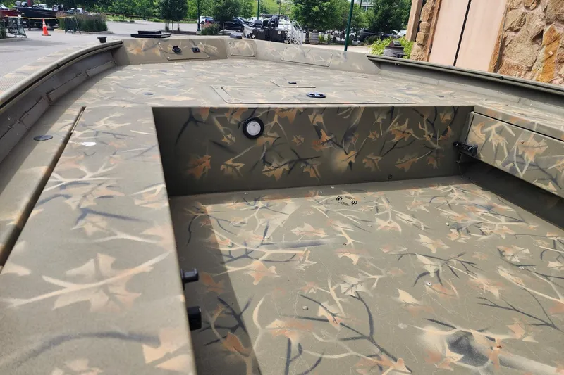 Slide: The Image of 2022 GRIZZLEY 1654SPT boat interior with camouflage pattern, parked outdoors. - 5