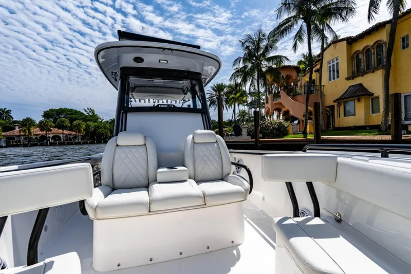Slide: The Image of 2021 Everglades 295 Center Console boat with white seating, under a clear blue sky. - 13
