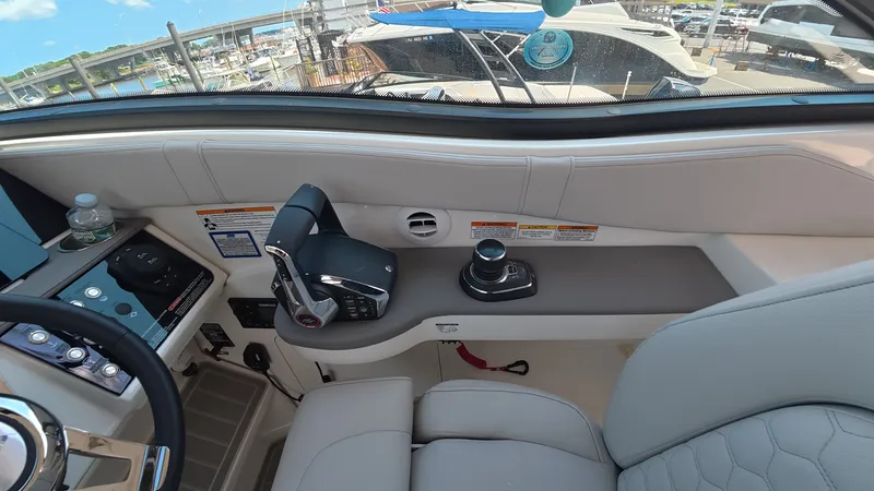 Slide: The Image of The cockpit of a Sea Ray Sundancer 320 Outboard with modern controls and comfortable seating. - 15