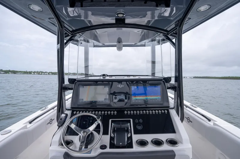 Slide: The Image of 2024 Fountain Bluewater 34 Tournament Edition boat dashboard with dual screens on open water. - 38