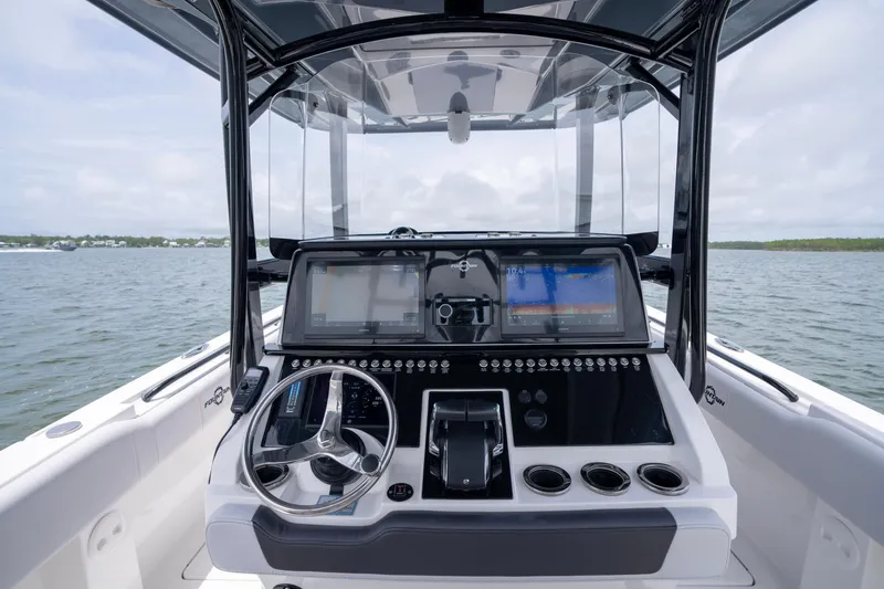 Slide: The Image of 2024 Fountain Bluewater 34 Tournament Edition boat dashboard with dual screens and steering wheel. - 50