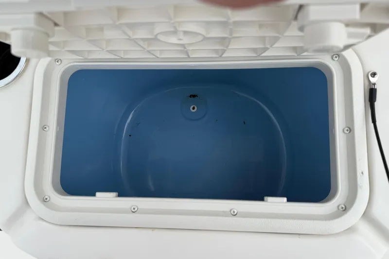 Slide: The Image of Open storage compartment in 2020 Carolina Skiff 21 LS boat, featuring a blue interior. - 61