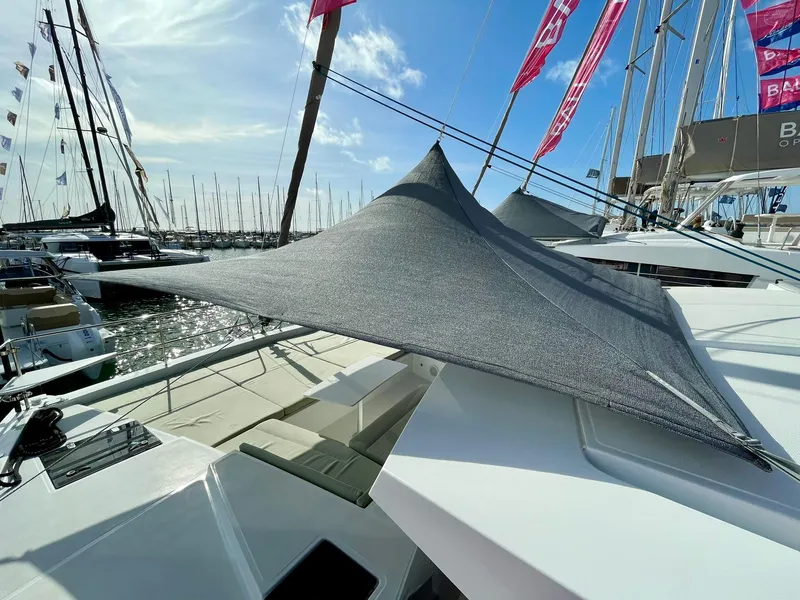 Slide: The Image of Modern Bali 4.2 yacht with sunshade, docked at marina, under clear blue sky. - 35