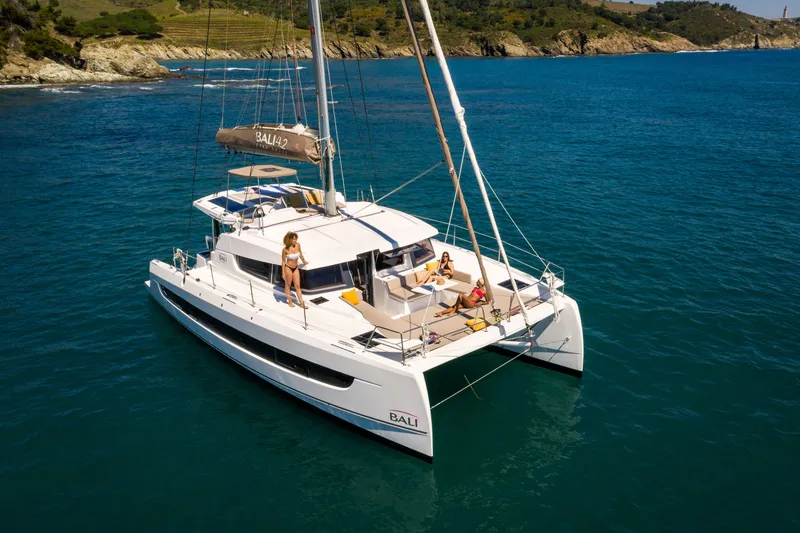 Slide: The Image of Modern Bali 4.2 catamaran sailing in clear blue waters, 2026 model. - 42