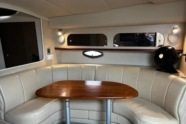 Slide: The Image of Interior of 2000 Cruisers Yachts 3575 Express with beige seating and wooden table. - 2