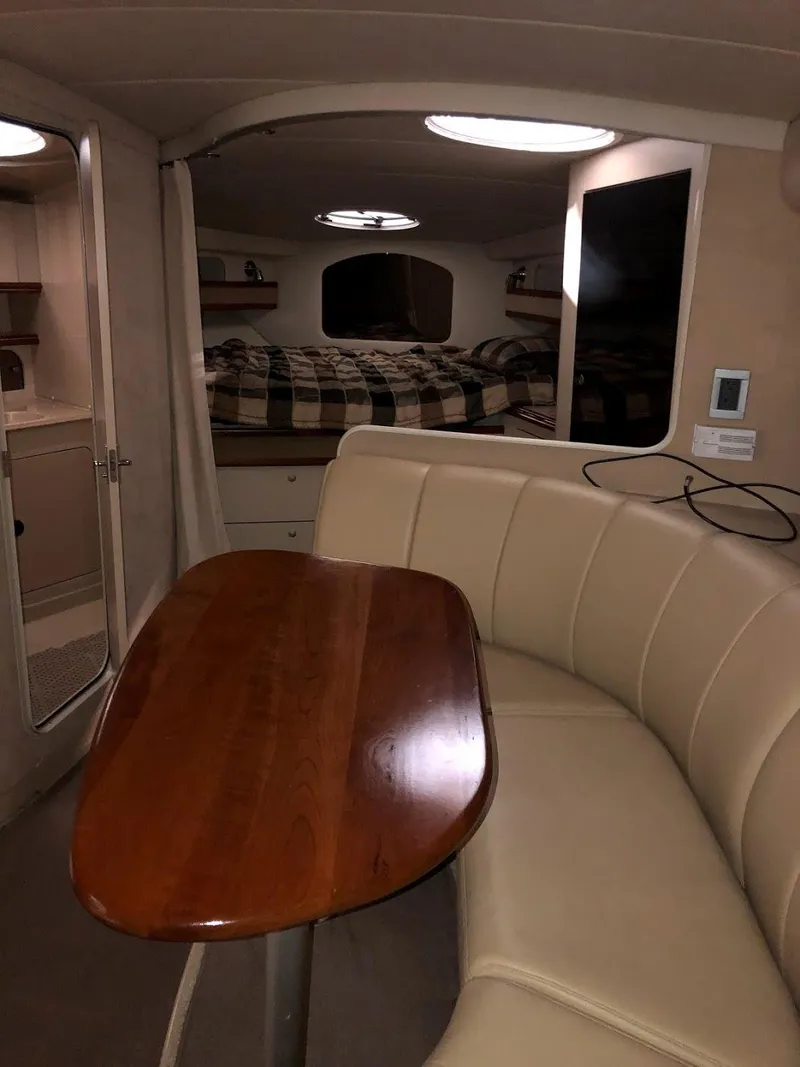 Slide: The Image of Interior of a 2000 Cruisers Yachts 3575 Express with table and seating area. - 26