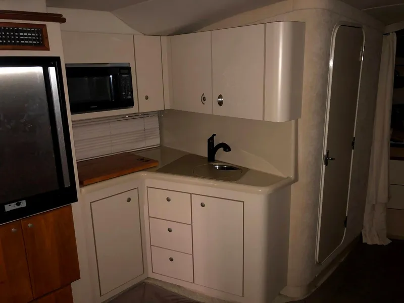 Slide: The Image of 2000 Cruisers Yachts 3575 Express kitchen area with sink and microwave. - 27