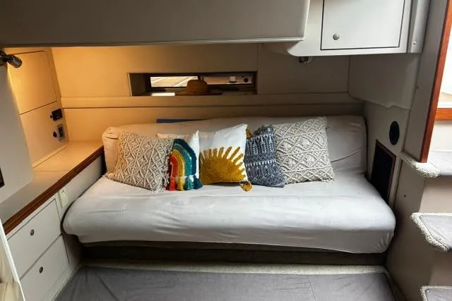 Slide: The Image of Interior of 2000 Cruisers Yachts 3575 Express with cozy sofa and decorative pillows. - 3