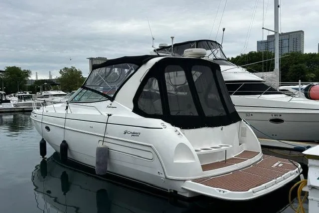 Slide: The Image of 2000 Cruisers Yachts 3575 Express docked at marina, featuring sleek design and black canopy. - 38