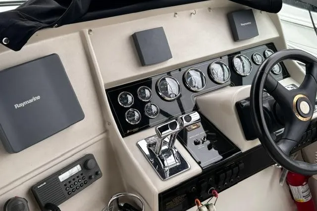 Slide: The Image of Control panel of 2000 Cruisers Yachts 3575 Express with steering wheel and navigation instruments. - 4