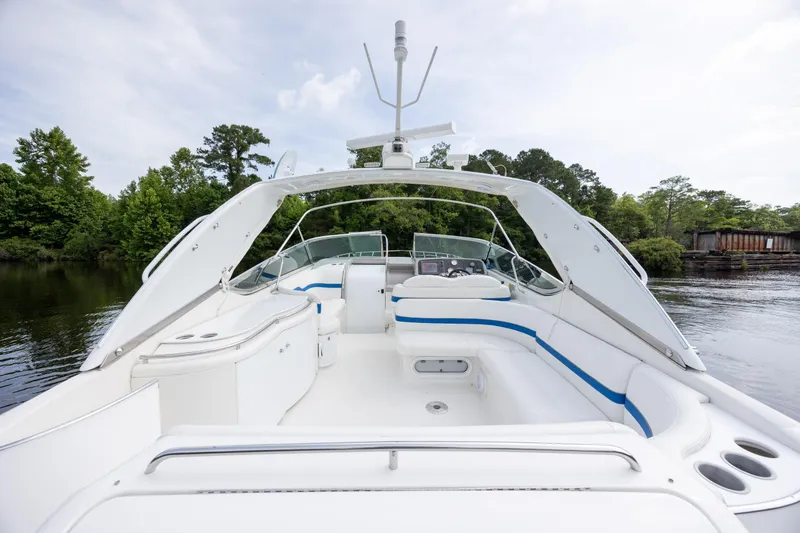 Slide: The Image of 2003 Formula 400 Super Sport boat with spacious deck, white seating, and blue accents on a calm river. - 13