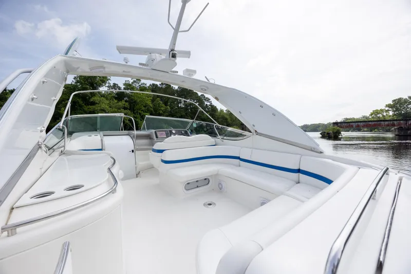 Slide: The Image of 2003 Formula 400 Super Sport boat with spacious white seating and sleek design on a calm river. - 14
