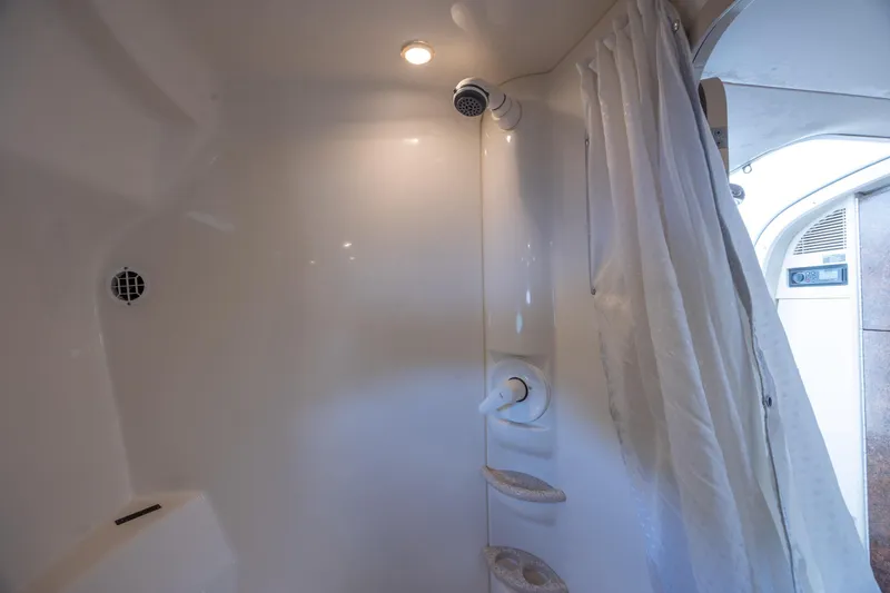 Slide: The Image of Interior shower of 2003 Formula 400 Super Sport boat, featuring white walls and curtain. - 25