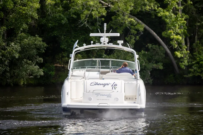 Slide: The Image of 2003 Formula 400 Super Sport boat cruising on a serene river, surrounded by lush greenery. - 3