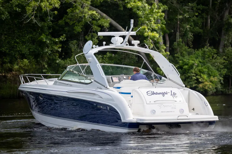 Slide: The Image of 2003 Formula 400 Super Sport boat cruising on a serene river. - 4