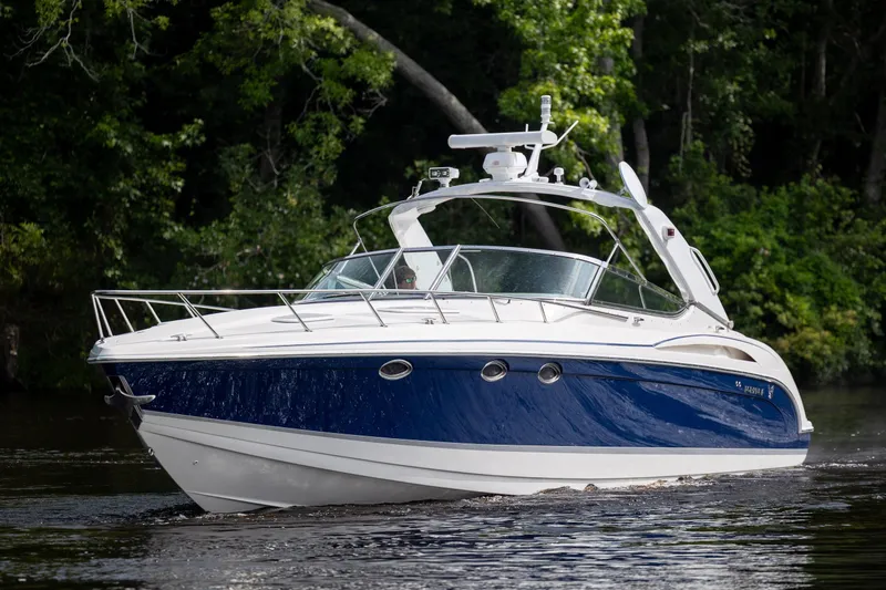 Slide: The Image of 2003 Formula 400 Super Sport boat cruising on a calm river with lush greenery. - 7
