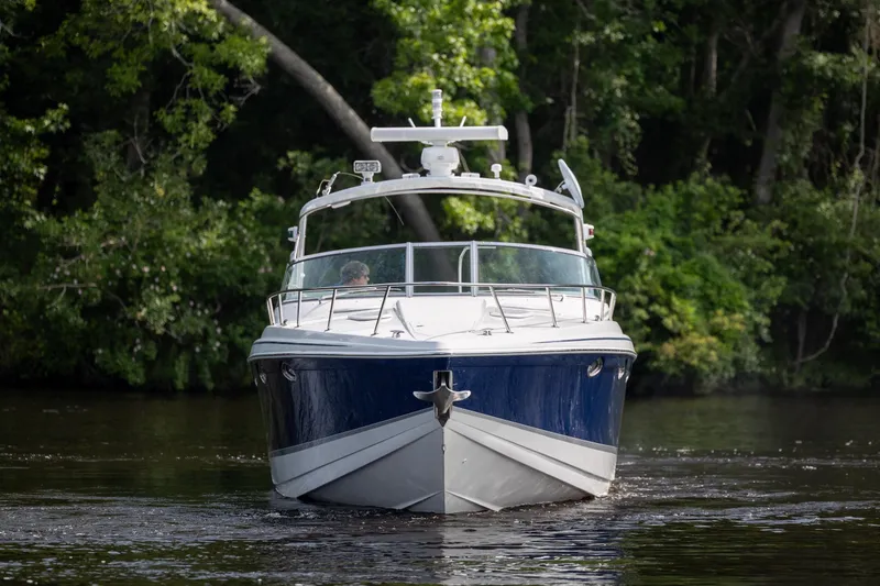Slide: The Image of 2003 Formula 400 Super Sport boat cruising on a river with lush greenery. - 8