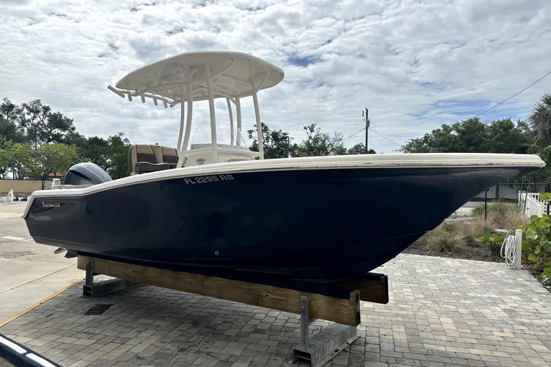 Slide: The Image of 2018 Tidewater 220 LXF boat on display, blue hull, outdoor setting. - 1