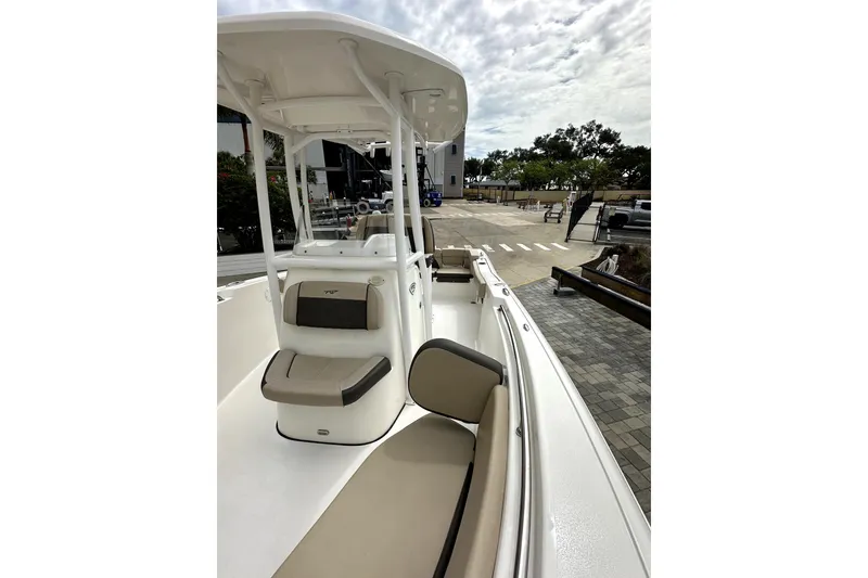 Slide: The Image of 2018 Tidewater 220 LXF boat with beige seating and T-top, docked outdoors. - 5