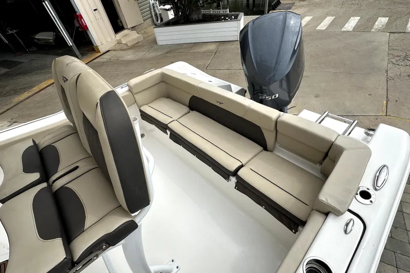 Slide: The Image of 2018 Tidewater 220 LXF boat interior with cushioned seating and outboard motor. - 8