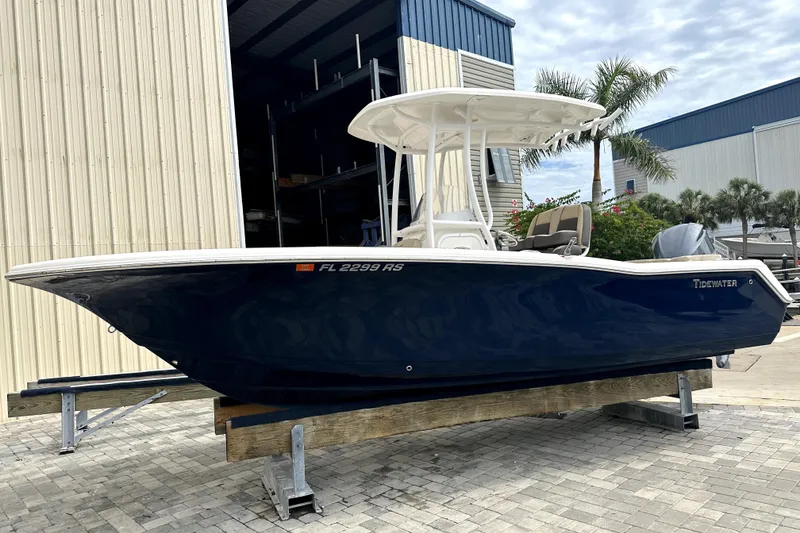 Slide: The Image of 2018 Tidewater 220 LXF boat on display, blue hull, parked outdoors. - 9