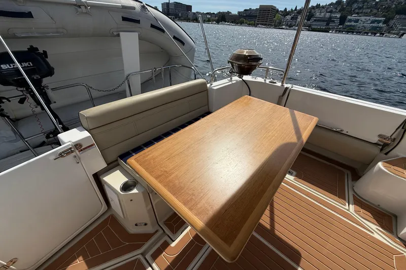 Slide: The Image of 2020 Ranger Tugs R-31 CB boat deck with wooden table and scenic waterfront view. - 11