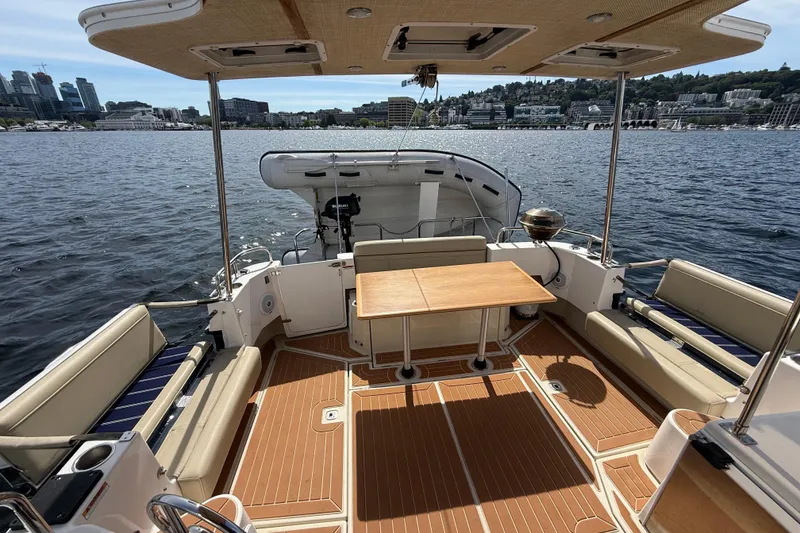 Slide: The Image of Spacious deck of 2020 Ranger Tugs R-31 CB with seating and table, overlooking waterfront. - 12