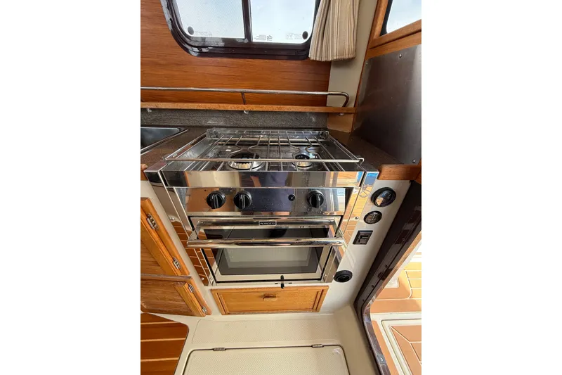 Slide: The Image of 2020 Ranger Tugs R-31 CB galley with stainless steel stove and oven. - 17