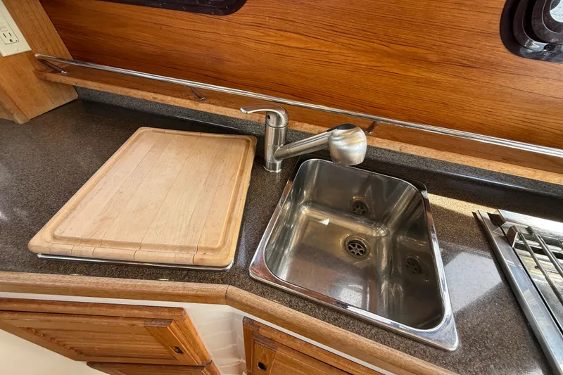 Slide: The Image of 2020 Ranger Tugs R-31 CB galley with sink and wooden cutting board. - 19