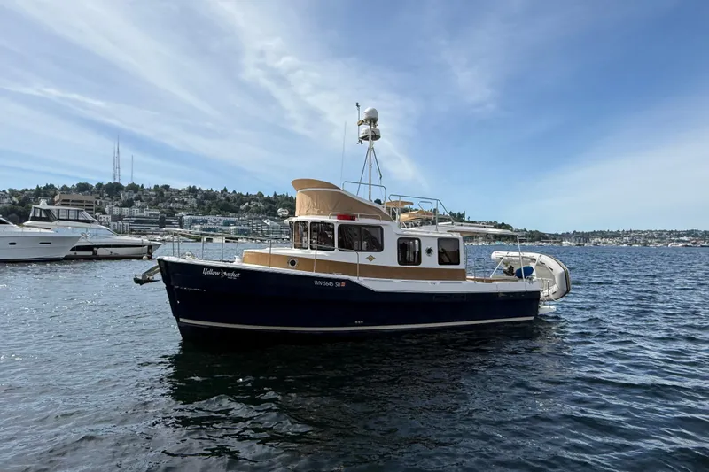 Slide: The Image of 2020 Ranger Tugs R-31 CB boat on calm water under a clear sky. - 2