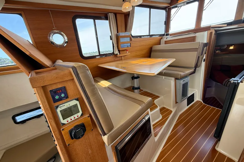 Slide: The Image of 2020 Ranger Tugs R-31 CB interior with wood accents and seating area. - 24