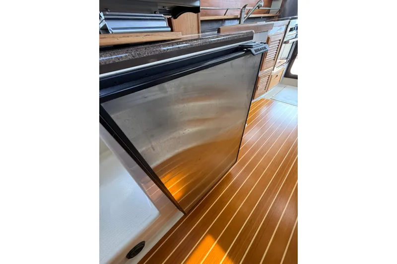 Slide: The Image of 2020 Ranger Tugs R-31 CB interior with stainless steel fridge and wooden flooring. - 29