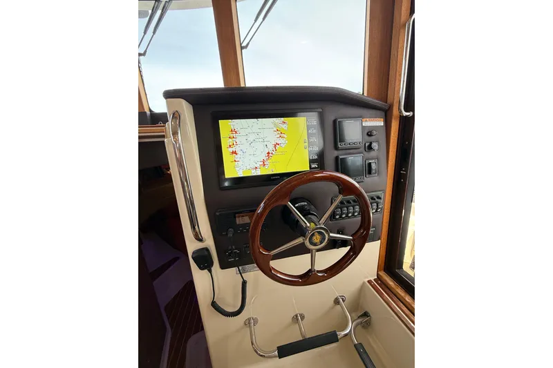 Slide: The Image of 2020 Ranger Tugs R-31 CB helm with navigation display and wooden steering wheel. - 32