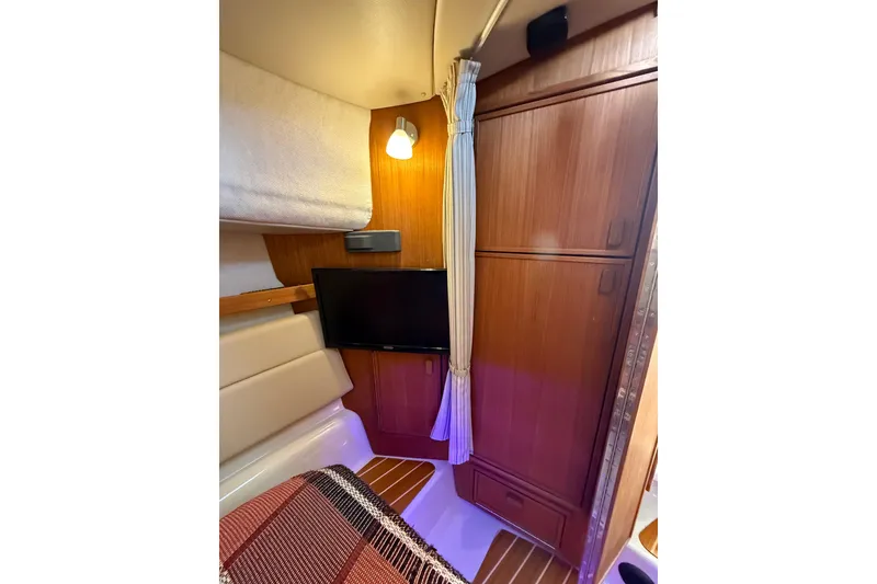 Slide: The Image of 2020 Ranger Tugs R-31 CB cabin interior with TV, wood paneling, and cozy lighting. - 36