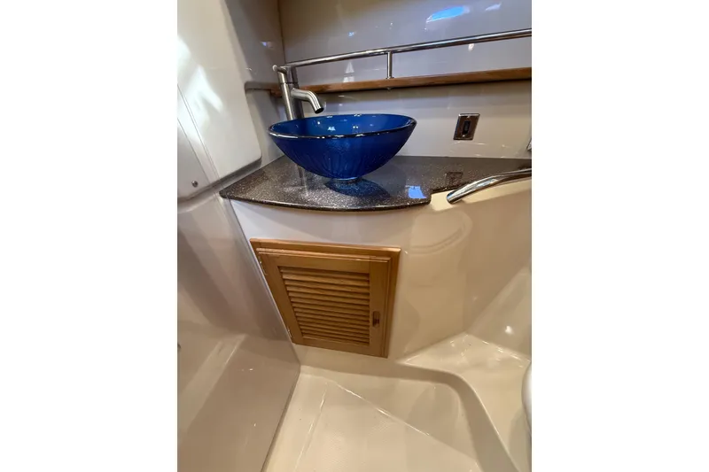 Slide: The Image of 2020 Ranger Tugs R-31 CB bathroom with blue vessel sink and wooden cabinet. - 38